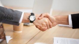 Close up view of handshake, two businessmen in suits shaking hands as concept of trust, good partnership deal, signing contract agreement at meeting, gratitude for help support in business