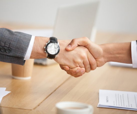 Close up view of handshake, two businessmen in suits shaking hands as concept of trust, good partnership deal, signing contract agreement at meeting, gratitude for help support in business